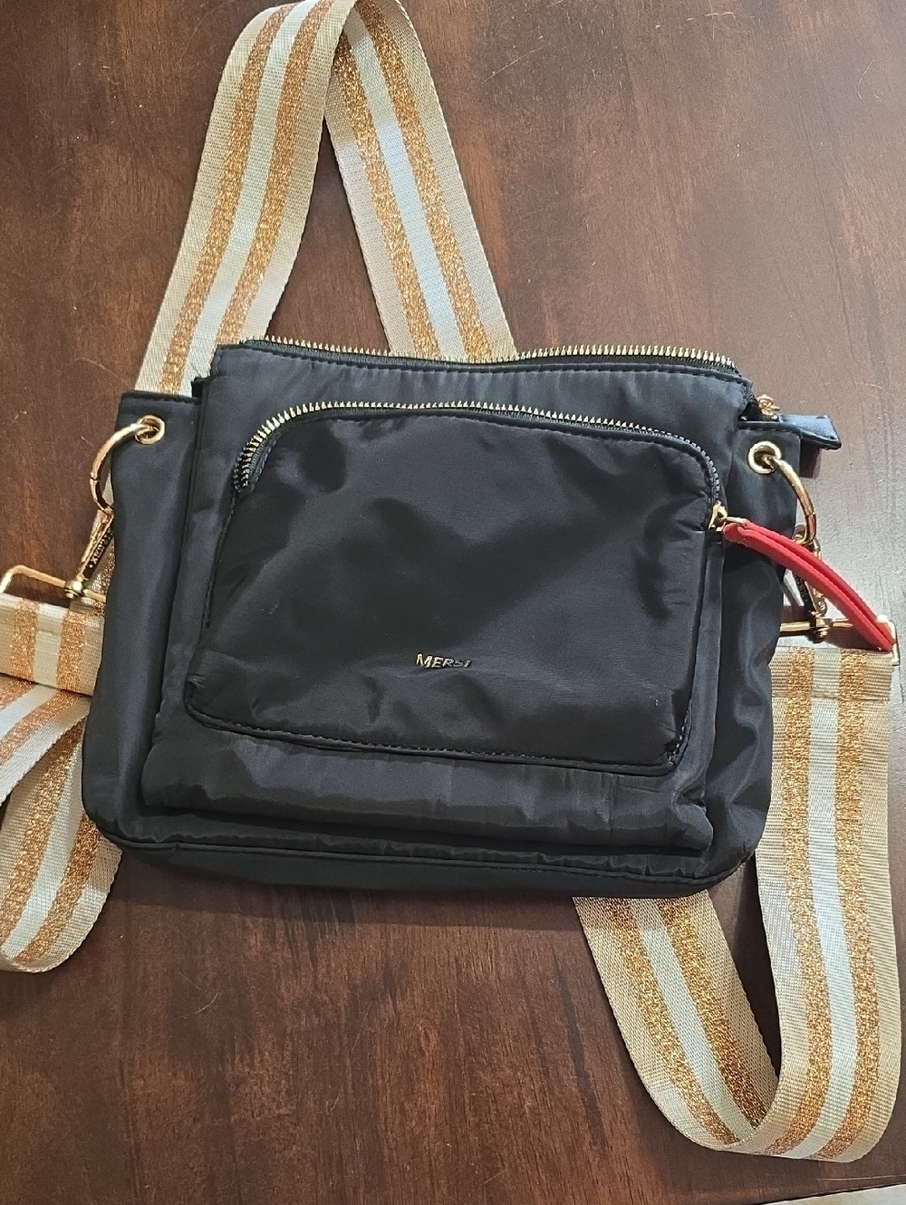 Black Crossbody Bag with Gold Hardware and Striped Strap